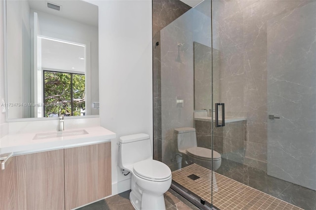 bathroom featuring tile patterned floors, a shower with door, vanity, and toilet