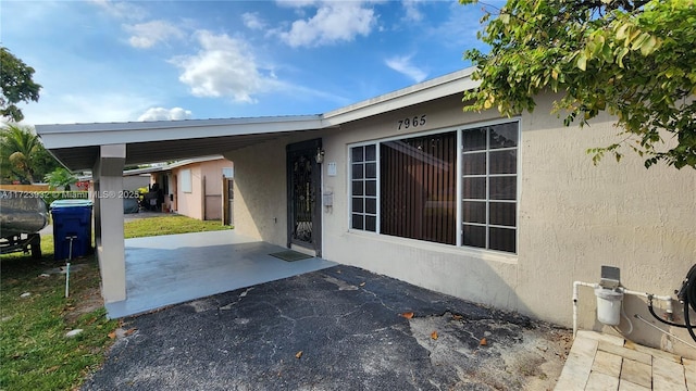 view of side of property featuring a patio area, an attached carport, and stucco siding