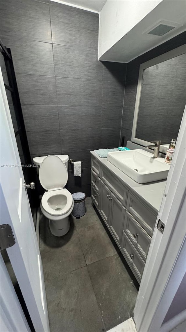 bathroom with toilet, tile patterned floors, visible vents, and vanity