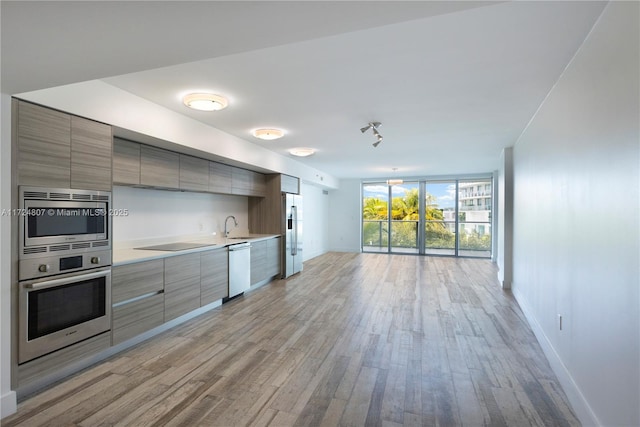 kitchen featuring light wood-style floors, modern cabinets, stainless steel appliances, and light countertops