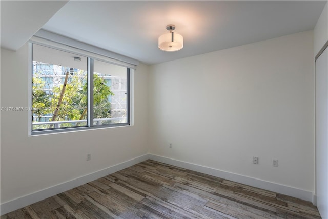 unfurnished room featuring wood finished floors and baseboards