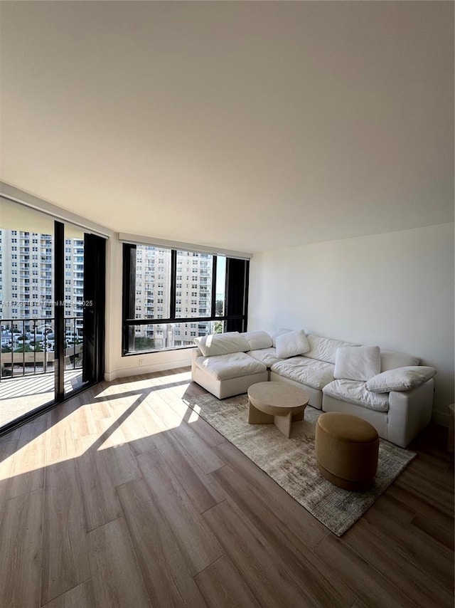 unfurnished living room featuring floor to ceiling windows and hardwood / wood-style floors