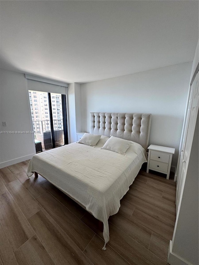 bedroom featuring dark hardwood / wood-style flooring and access to exterior