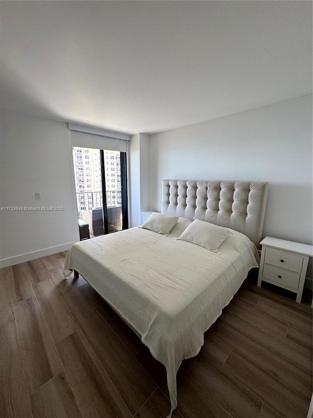 bedroom with access to outside and dark hardwood / wood-style floors