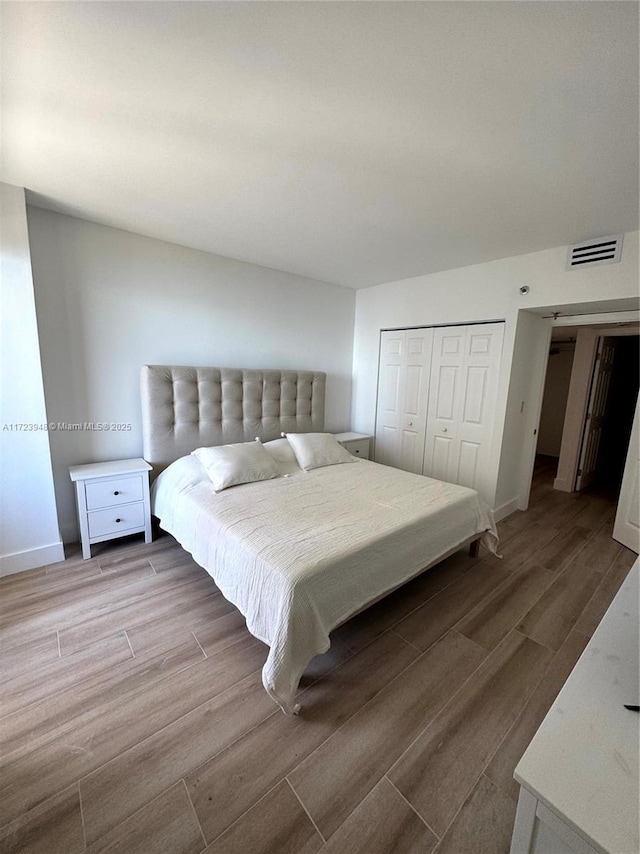 bedroom featuring hardwood / wood-style floors and a closet