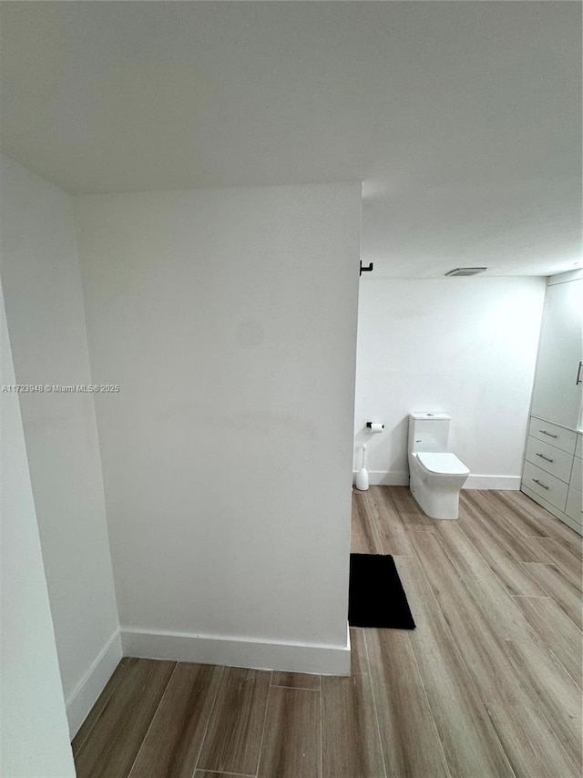 bathroom with hardwood / wood-style floors and toilet