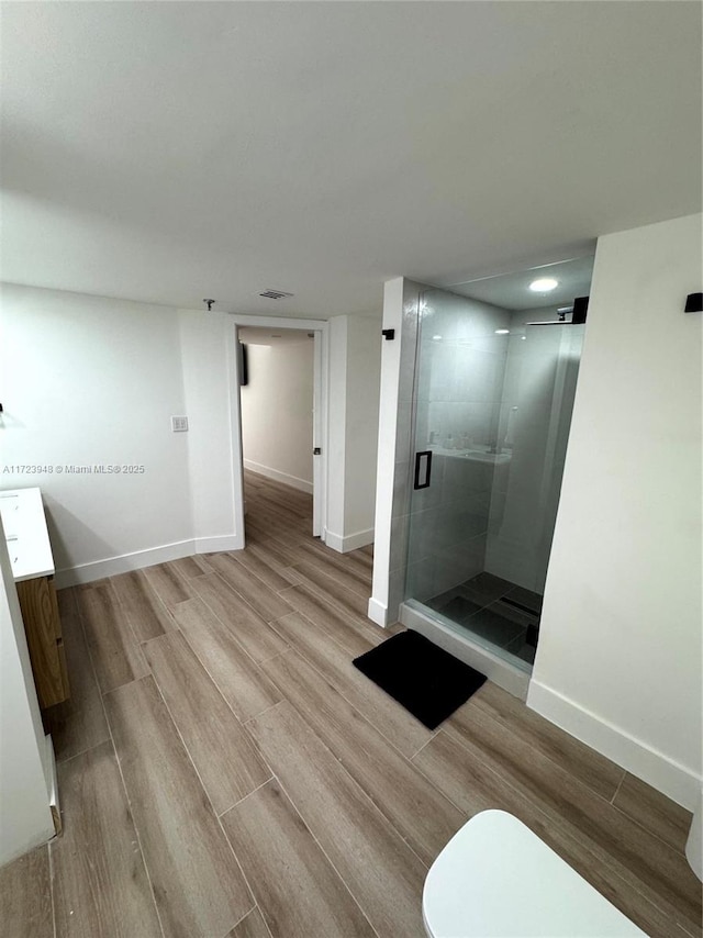 bathroom featuring vanity, toilet, an enclosed shower, and wood-type flooring