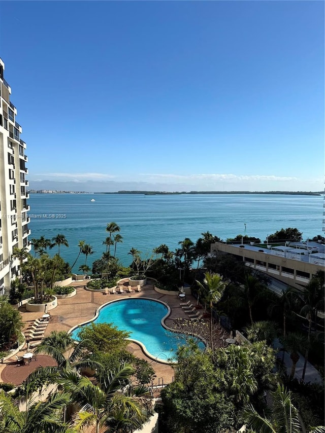 view of pool with a water view and a patio