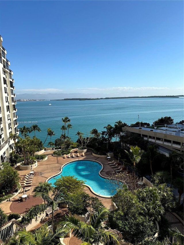 view of swimming pool featuring a water view and a patio