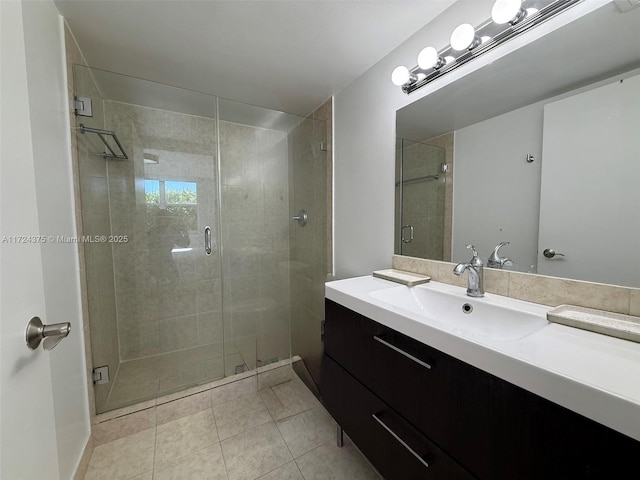 bathroom with a shower with shower door, tile patterned floors, and vanity