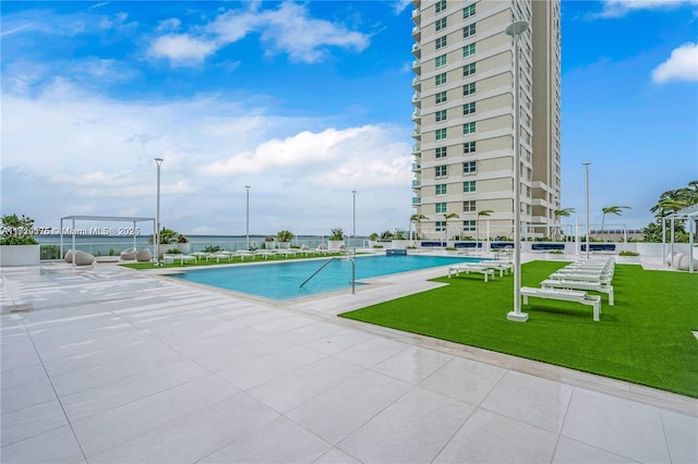 view of pool featuring a lawn and a patio