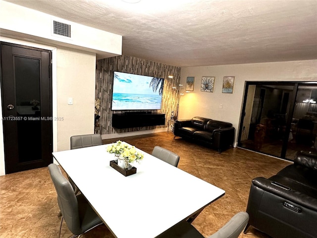 living room with a textured ceiling and wooden walls