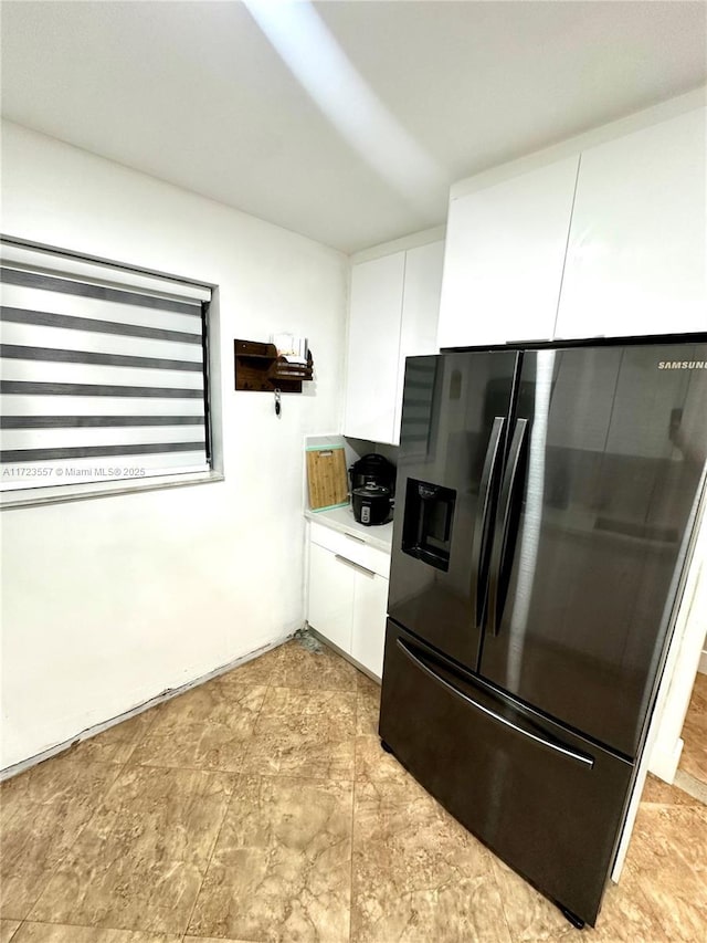 kitchen featuring white cabinets and black fridge with ice dispenser