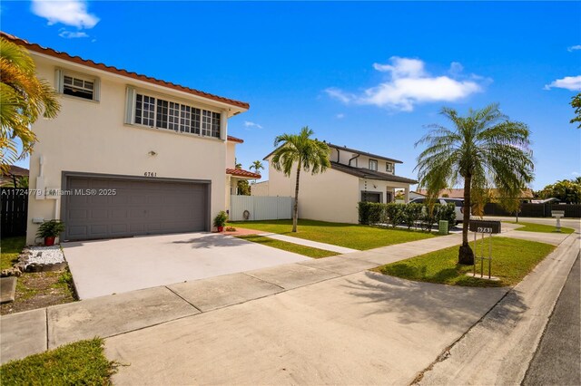 mediterranean / spanish-style home featuring a garage and a front lawn