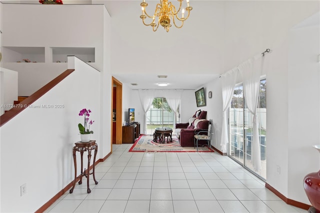 interior space featuring a high ceiling, a notable chandelier, and baseboards