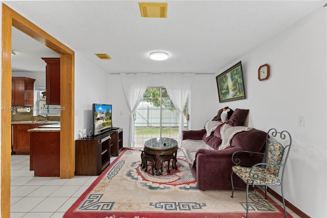 living area with light tile patterned floors and visible vents