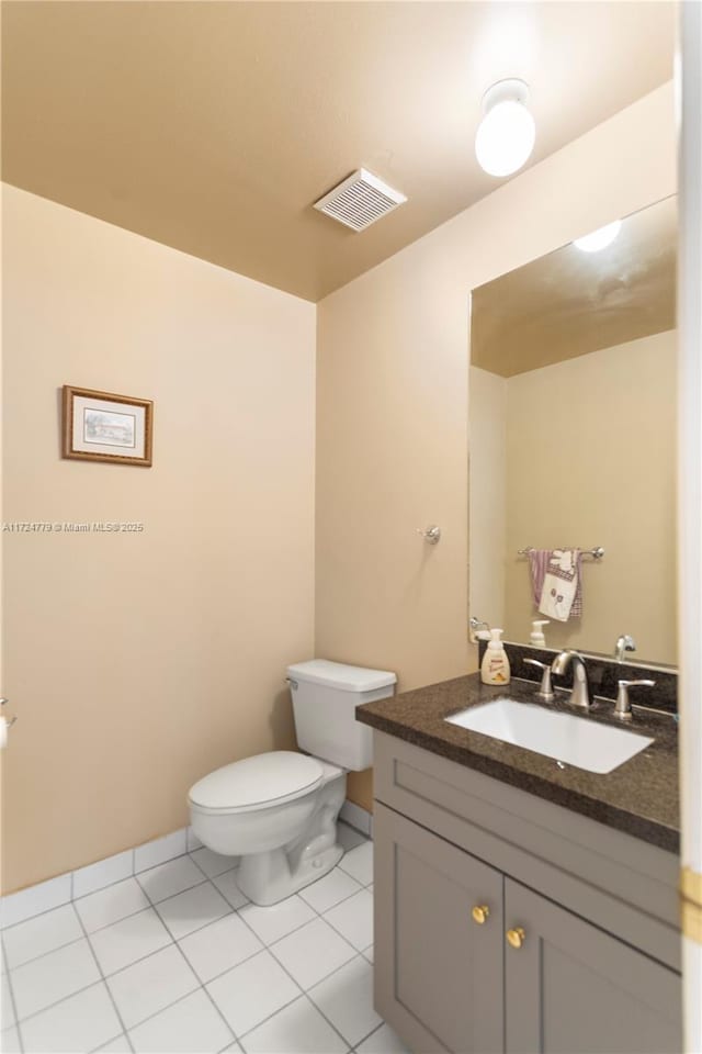 bathroom with toilet, vanity, visible vents, and tile patterned floors