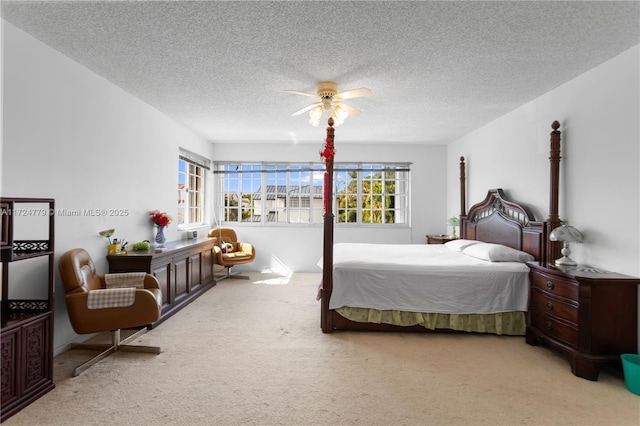 bedroom with carpet floors, ceiling fan, and a textured ceiling