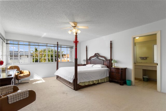 carpeted bedroom with connected bathroom, a textured ceiling, and ceiling fan