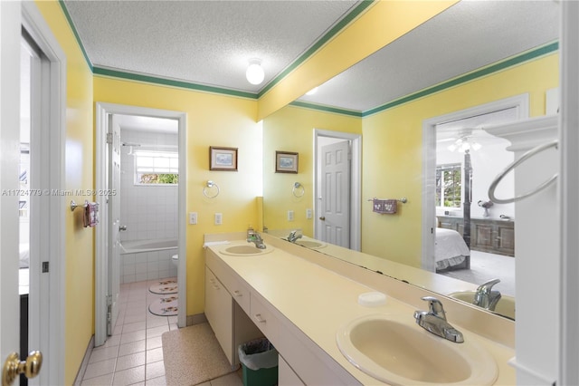 full bath with connected bathroom, a sink, a textured ceiling, tiled tub, and tile patterned floors