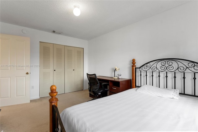 bedroom featuring a closet, carpet flooring, visible vents, and a textured ceiling