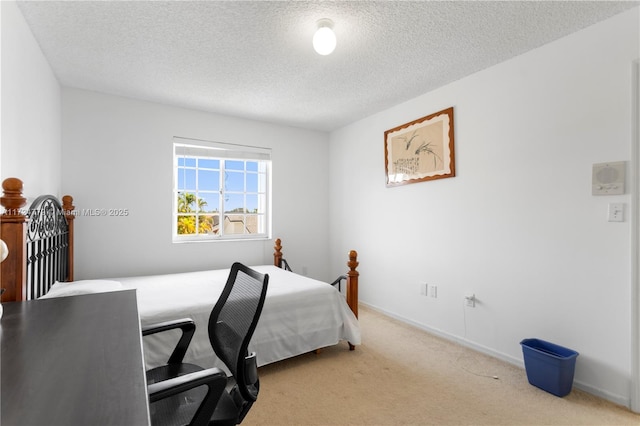 carpeted bedroom featuring baseboards and a textured ceiling