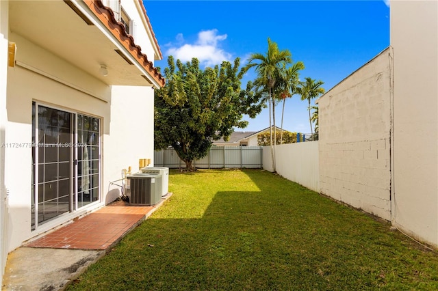 view of yard with a fenced backyard and central air condition unit