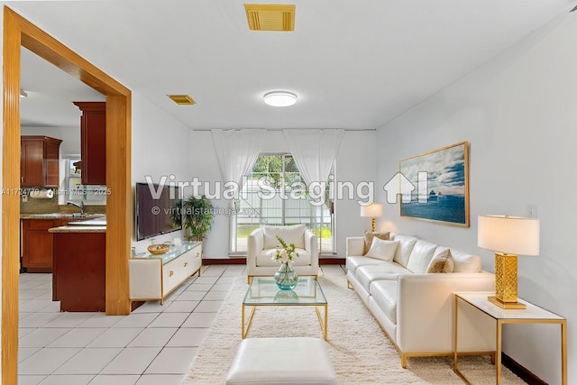 living area with visible vents and light tile patterned floors