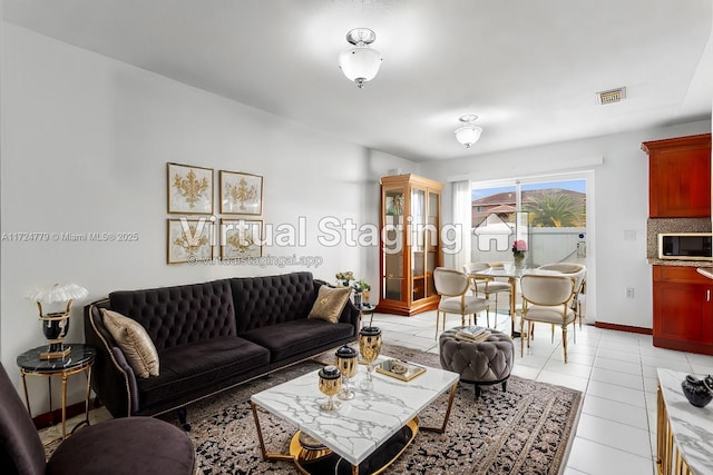 living area featuring visible vents, baseboards, and light tile patterned flooring