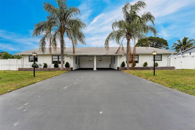 ranch-style home featuring a carport and a front lawn