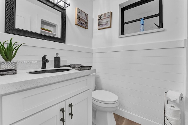 bathroom with vanity, hardwood / wood-style flooring, and toilet