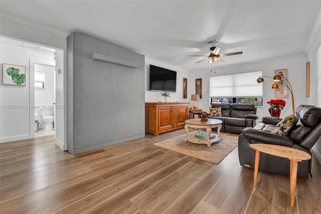 living room featuring hardwood / wood-style flooring, ceiling fan, and crown molding