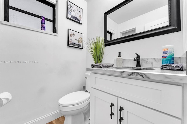 bathroom featuring vanity, hardwood / wood-style flooring, and toilet