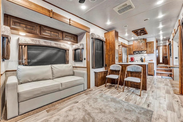 interior space featuring ornamental molding, sink, and light hardwood / wood-style flooring