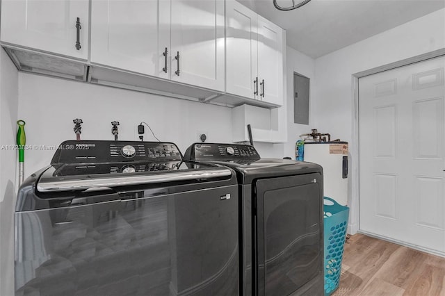 clothes washing area featuring cabinets, light wood-type flooring, water heater, independent washer and dryer, and electric panel