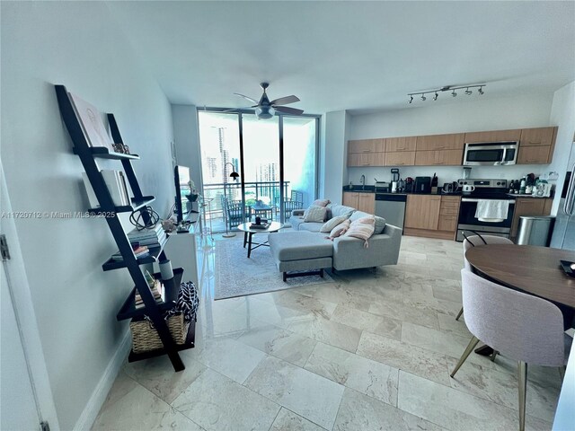 kitchen with appliances with stainless steel finishes, dark stone countertops, light tile patterned flooring, and sink