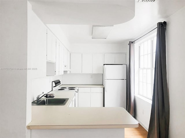 kitchen with white cabinetry, sink, white appliances, and light hardwood / wood-style flooring