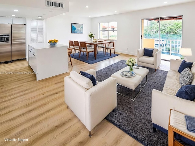 living room with light hardwood / wood-style flooring and a healthy amount of sunlight