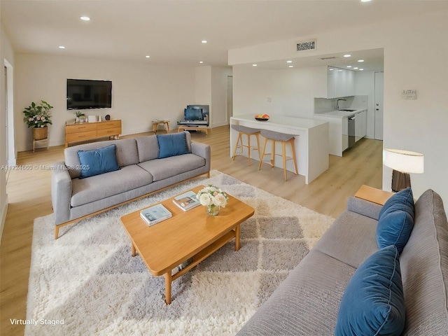 living room with sink and light wood-type flooring