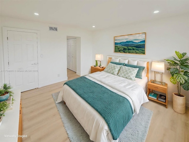 bedroom with light hardwood / wood-style floors and a closet