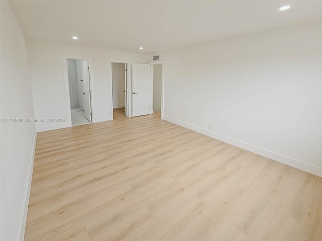 unfurnished bedroom with light hardwood / wood-style floors and connected bathroom