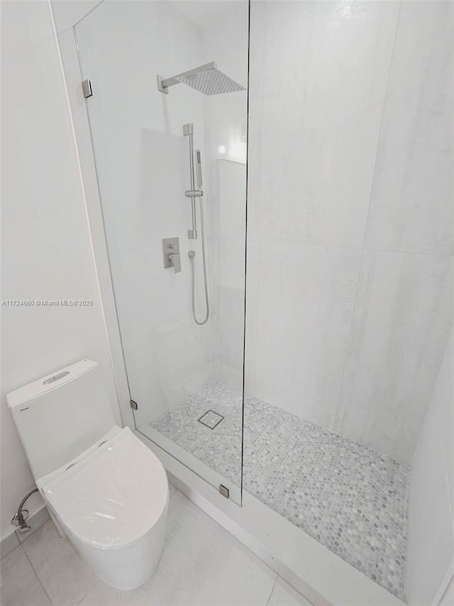 bathroom with tile patterned floors, toilet, and walk in shower