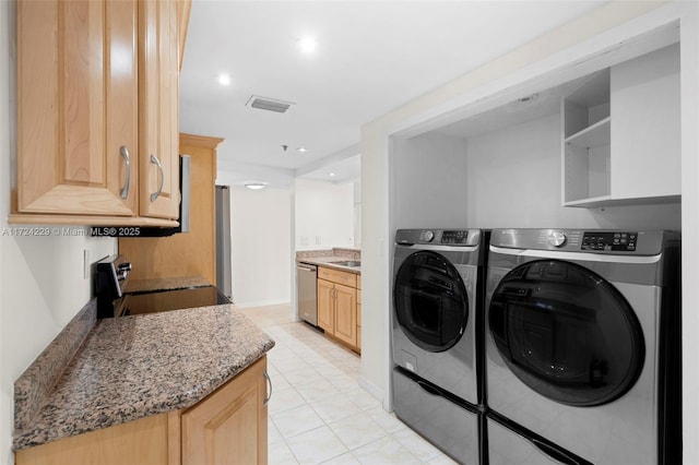 laundry room with washing machine and dryer and light tile patterned flooring