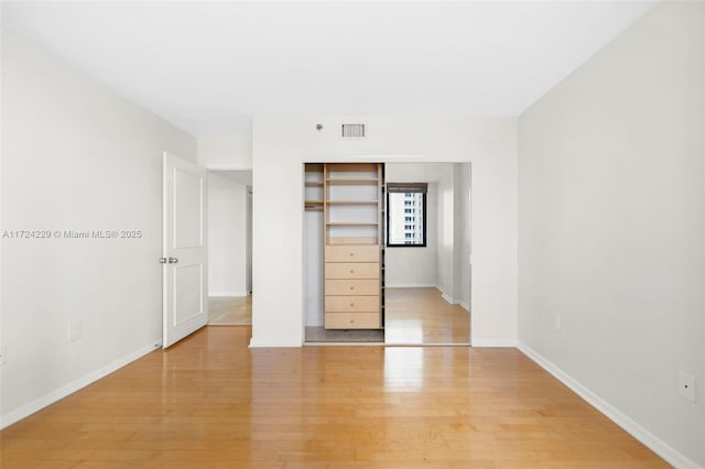 unfurnished bedroom with a closet and light wood-type flooring