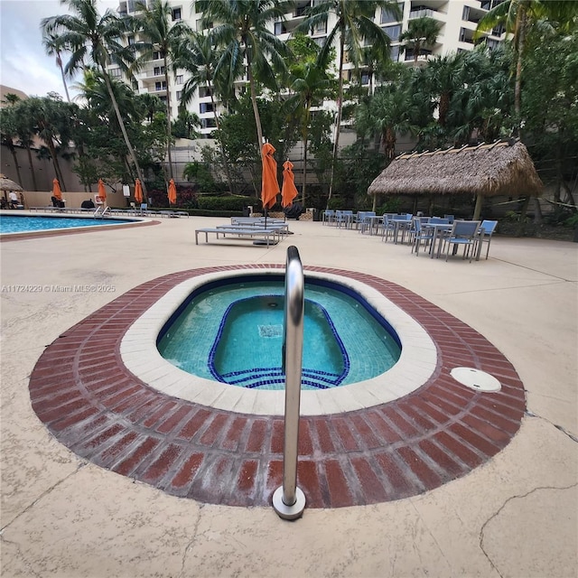 view of pool featuring a hot tub and a patio