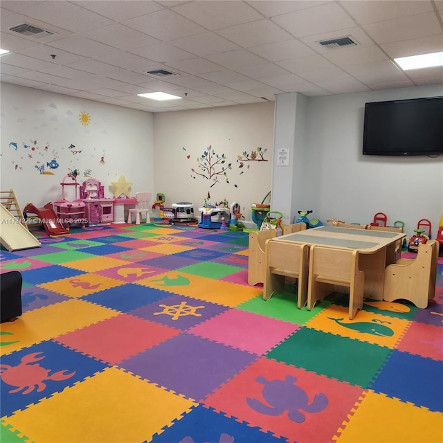 playroom featuring carpet flooring and a drop ceiling