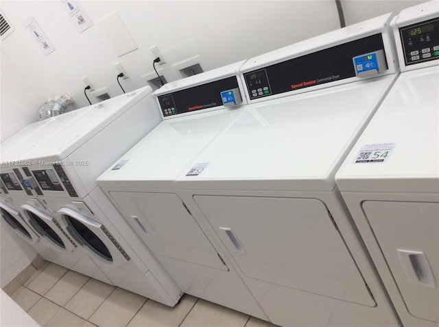 laundry room with washer and dryer and light tile patterned floors