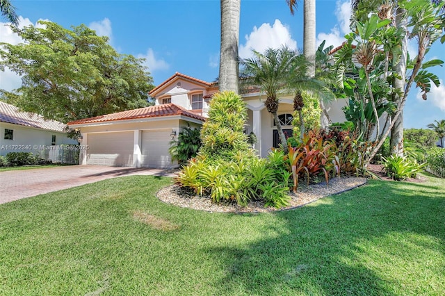 mediterranean / spanish home with a garage and a front lawn