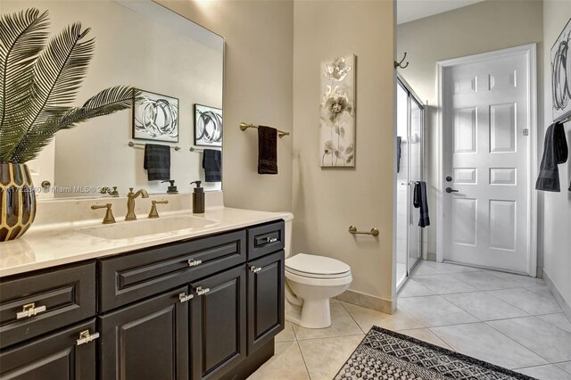 bathroom featuring an enclosed shower, vanity, tile patterned floors, and toilet