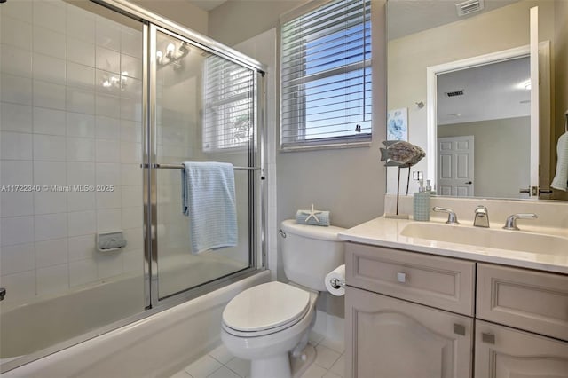 full bathroom featuring vanity, combined bath / shower with glass door, tile patterned floors, and toilet